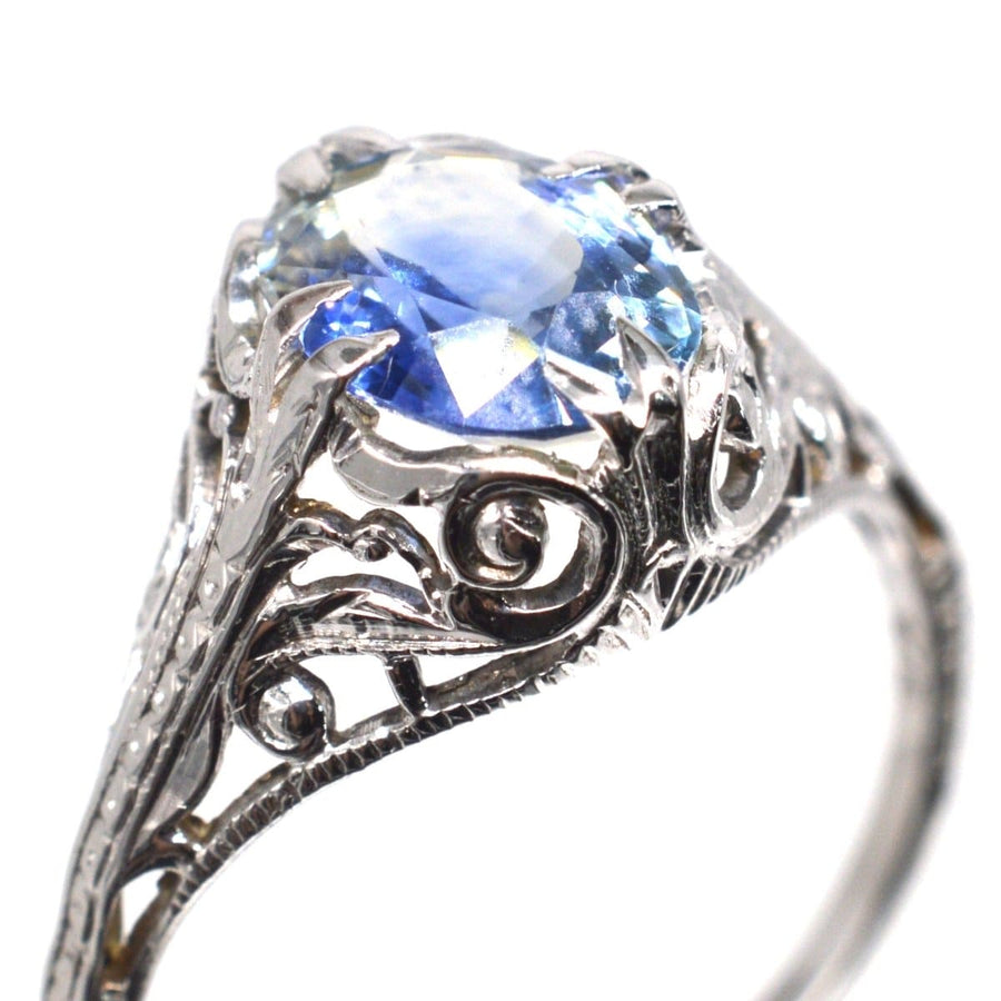 Belle Époque 18ct white gold ring featuring a cornflower blue sapphire and intricate foliate design.