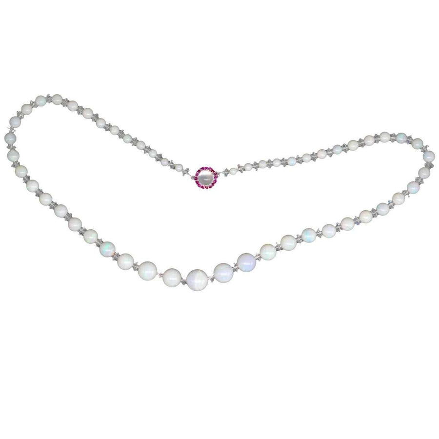 Early 20th century graduated opal bead necklace with ruby and moonstone clasp, elegant and luminous in design.