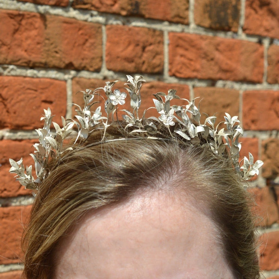 Mid 19th century silver leaf tiara worn by a model against a brick wall.