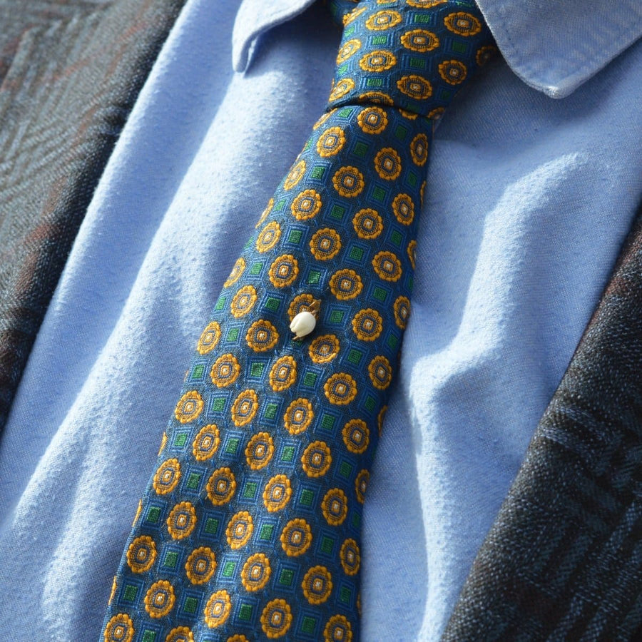 Rare Regency 9ct Gold carved white coral Lily of the Valley tie pin on a patterned tie.