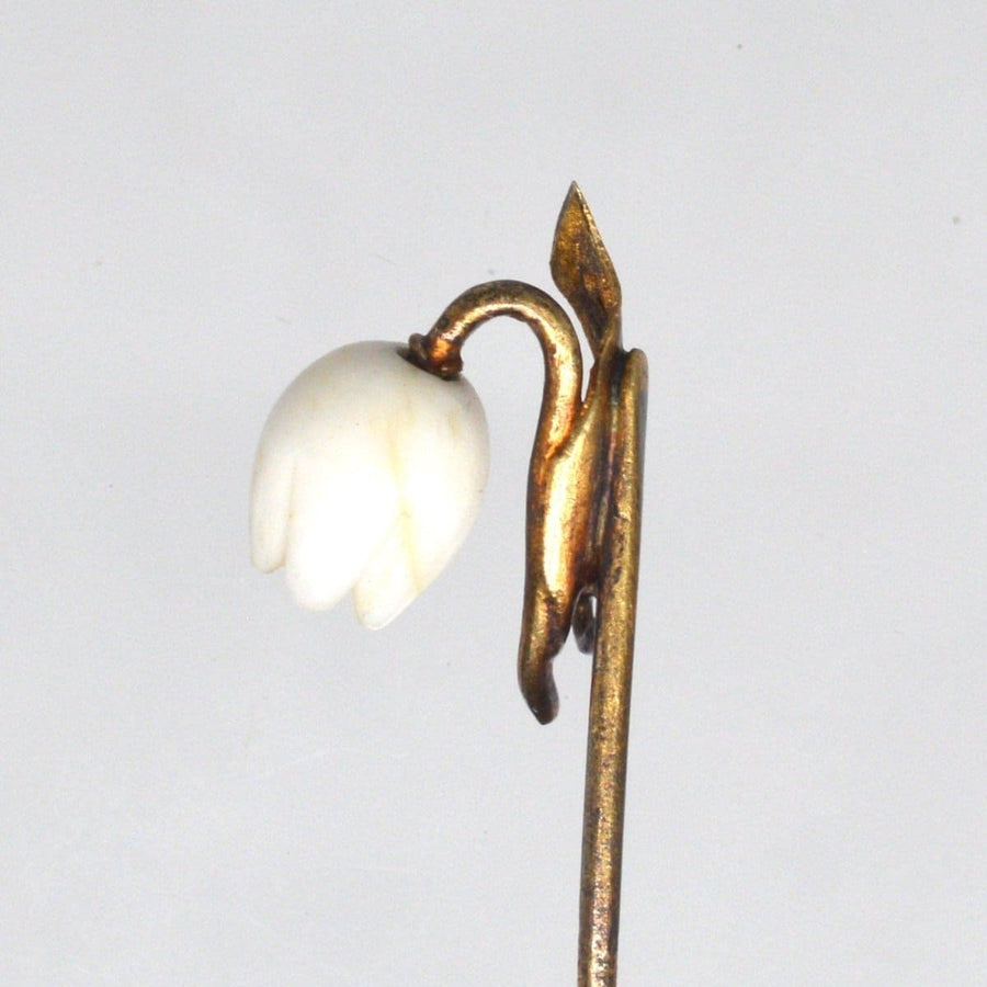 Rare Regency 9ct gold tie pin featuring a carved white coral Lily of the Valley flower, elegantly designed and in excellent condition.