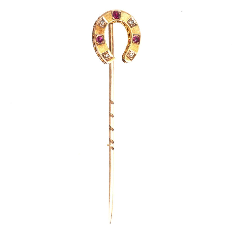 Victorian gold horseshoe tie pin adorned with rubies and diamonds, symbolizing luck and love.