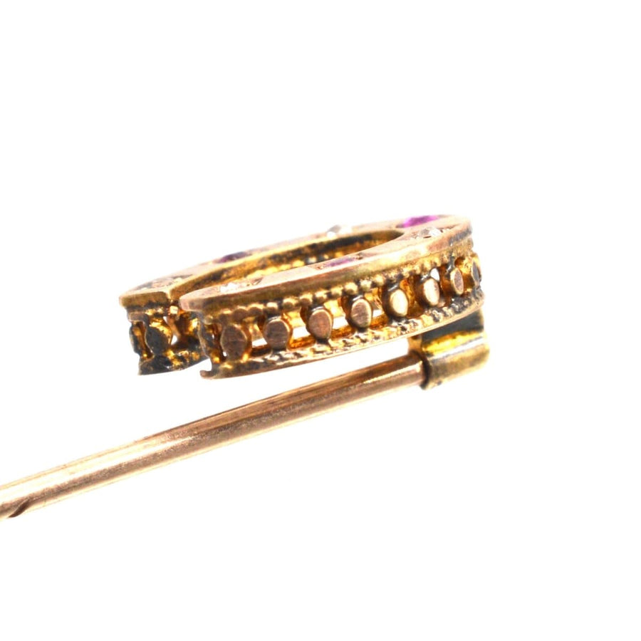 Victorian 15ct gold horseshoe tie pin with ruby and diamond embellishments, symbolizing luck and love.