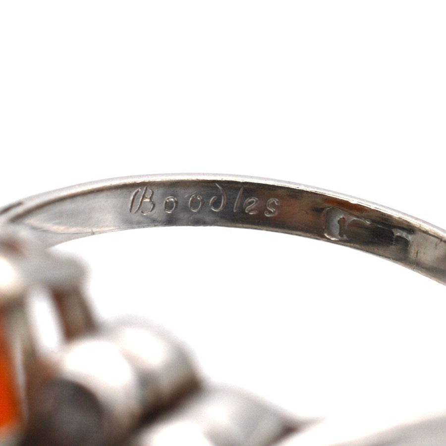 Close-up of Boodles inscription on the band of a 1960s platinum ring with fire opal and diamonds.