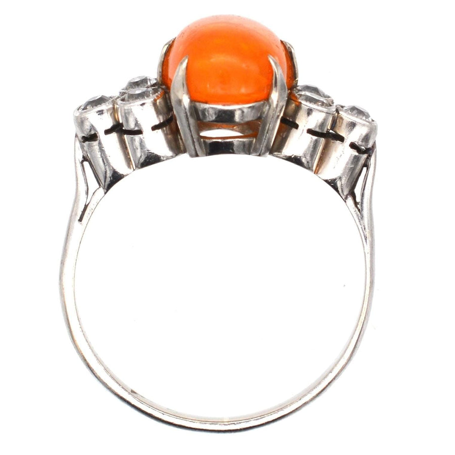 1960s Boodles platinum ring featuring a stunning fire jelly opal with diamonds on either side, showcasing vintage elegance.