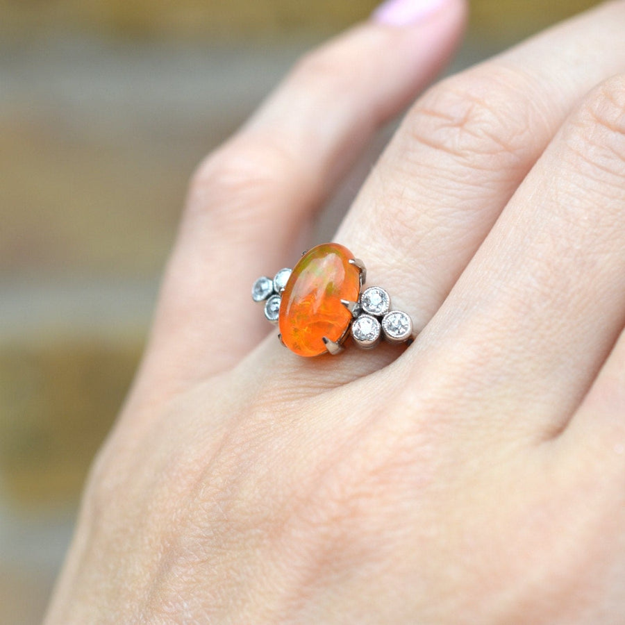 1960s Boodles vintage platinum ring featuring a rare fire opal and diamonds on a hand.