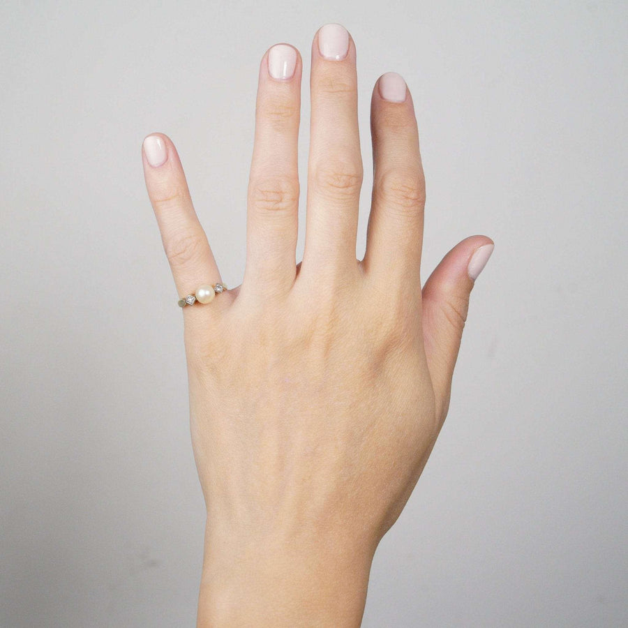 Art Deco 14ct gold ring featuring cultured pearls and diamonds, showcased on a hand with neutral nail polish.