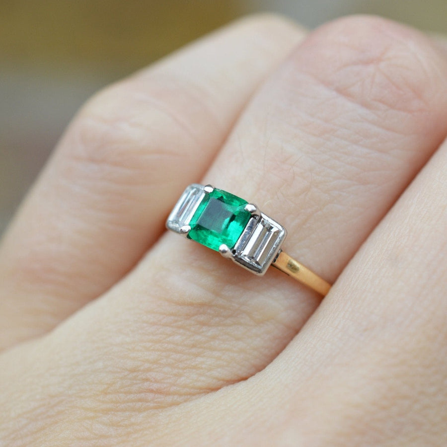 Art Deco 18ct gold and platinum three stone ring featuring Colombian emerald and baguette cut diamonds.