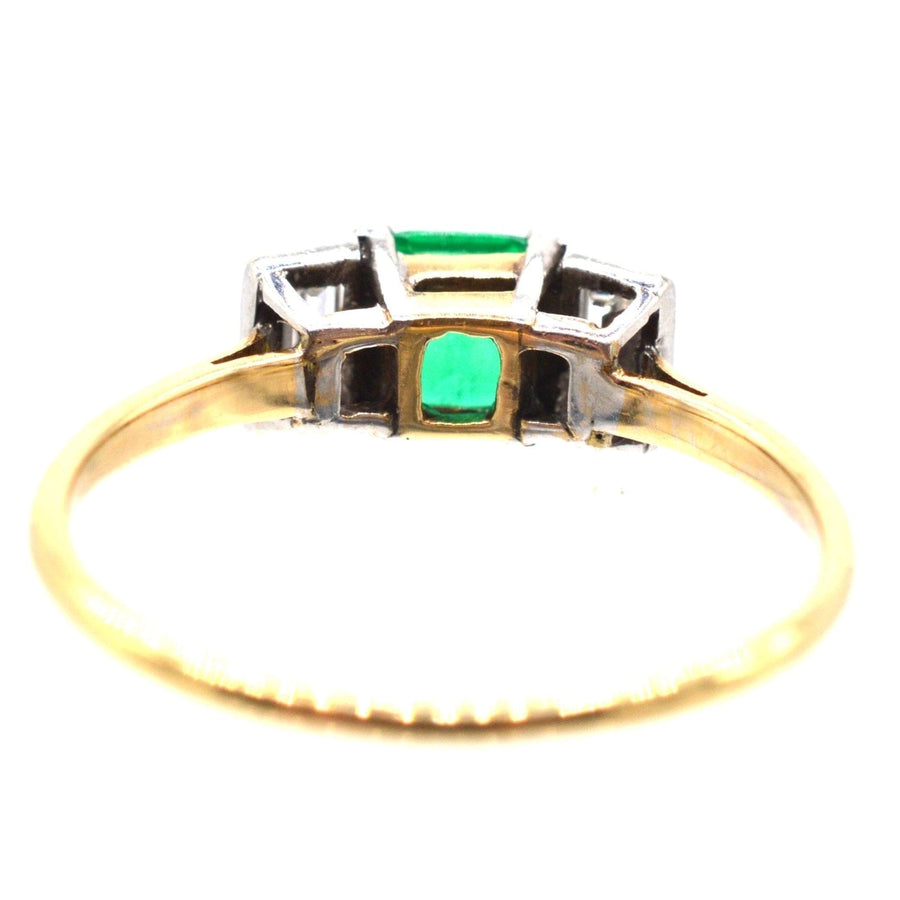 Art Deco 18ct gold and platinum three stone ring featuring a Columbian emerald and diamond baguettes.