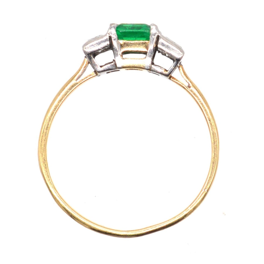Art Deco 18ct gold and platinum three stone ring featuring a Columbian emerald and baguette cut diamonds.
