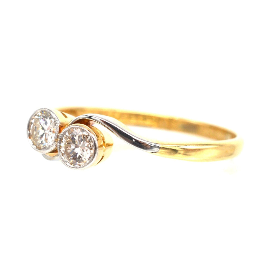 Art Deco 18ct gold and platinum two-stone diamond 'Toi et Moi' crossover ring, symbolizing love and unity.