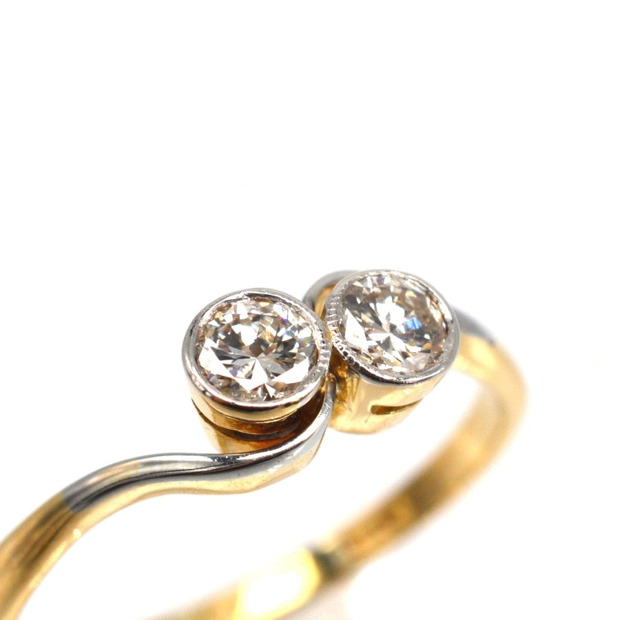 Art Deco 18ct gold and platinum 'Toi et Moi' crossover ring featuring two sparkling diamonds.