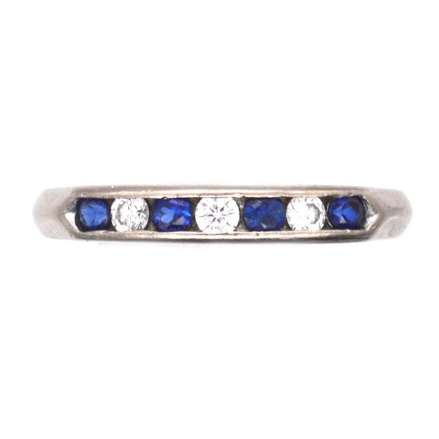 Vintage 18ct white gold half eternity ring featuring royal blue sapphires and brilliant white diamonds in channel setting.