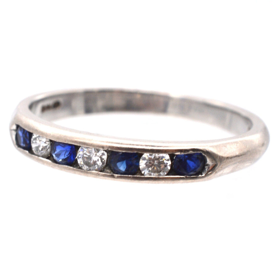 Vintage 18ct white gold half eternity ring featuring blue sapphires and diamonds in a channel setting.