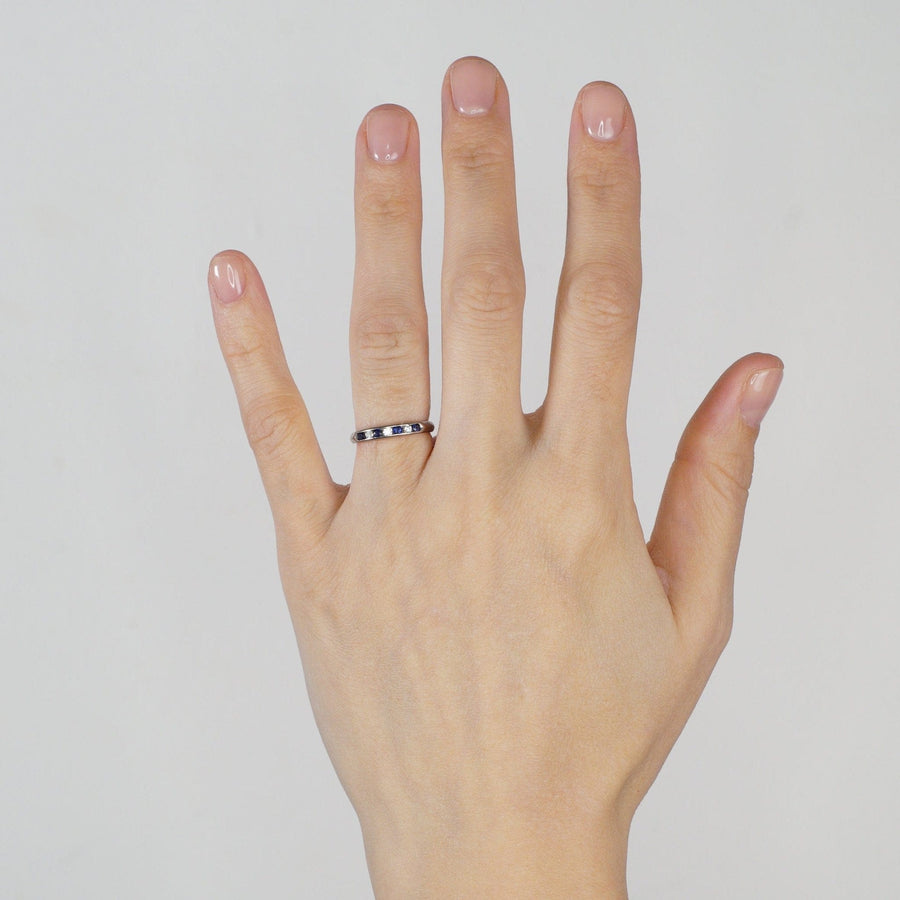 Vintage 18ct white gold half eternity ring with sapphires and diamonds displayed on a hand.