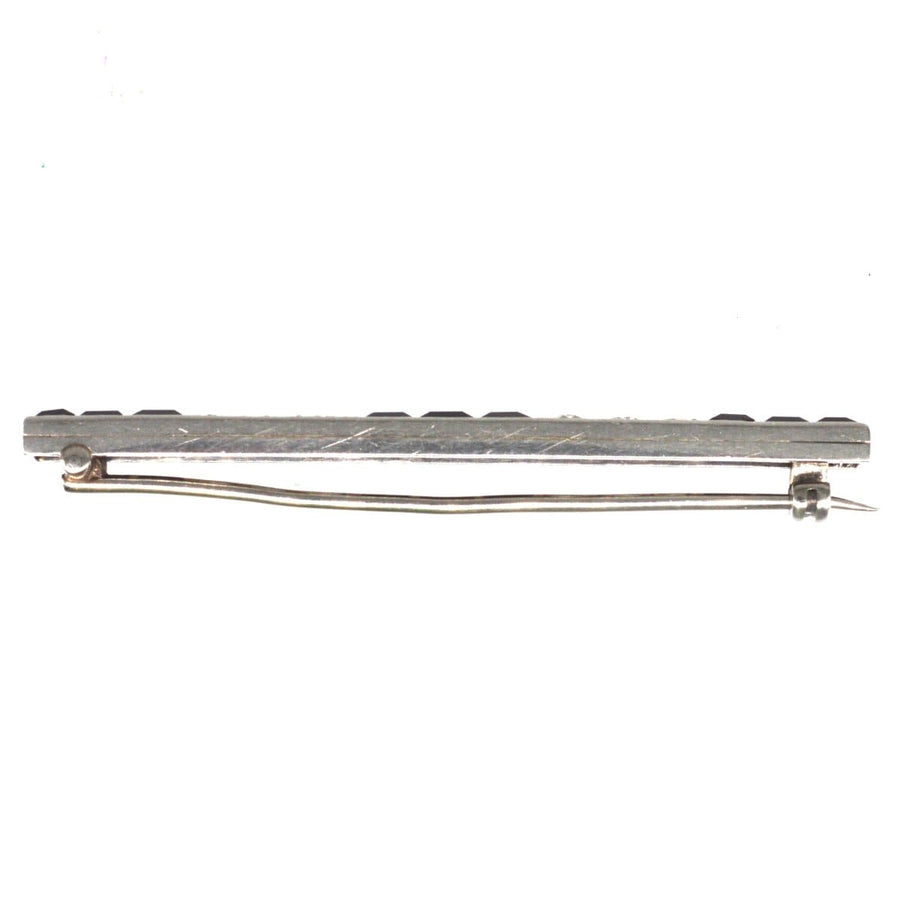 Art Deco platinum onyx bar brooch with diamonds, showcasing elegant black and white design.