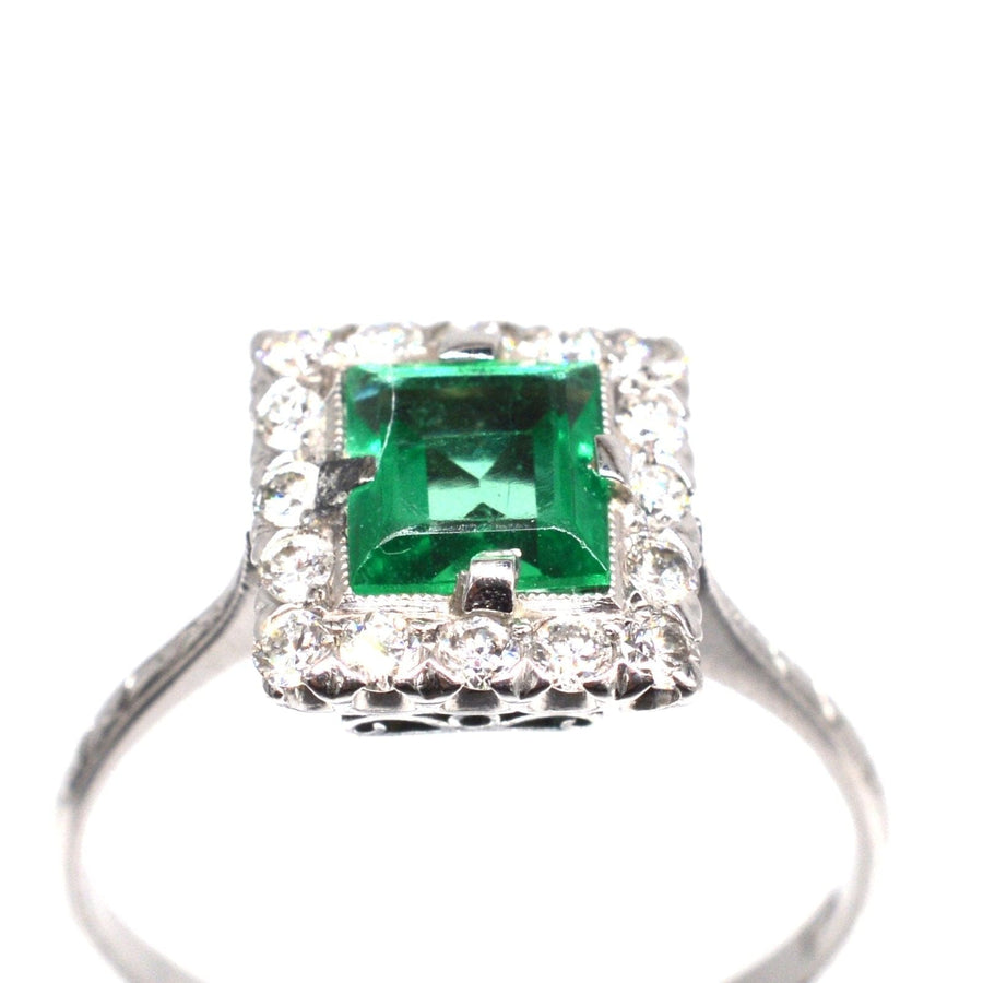 Art Deco platinum ring featuring rectangular emerald and diamond cluster, exquisite design, perfect for engagement.