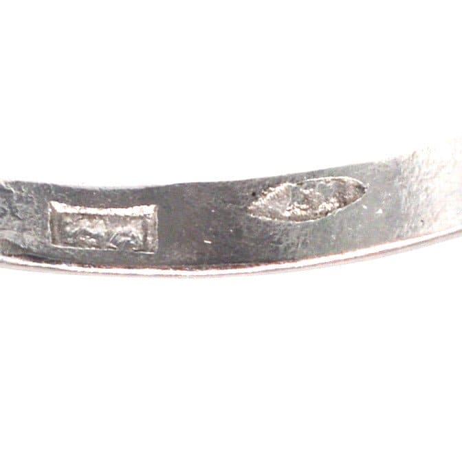 Close-up of the engraved markings on an Art Deco platinum ring, highlighting its craftsmanship and authenticity.