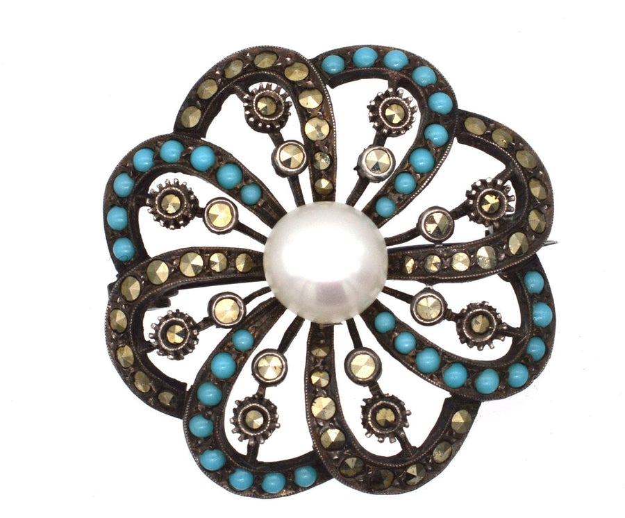 Art Deco silver brooch with marcasite accents, turquoise stones, and a central cultured pearl, 1930s Germany.