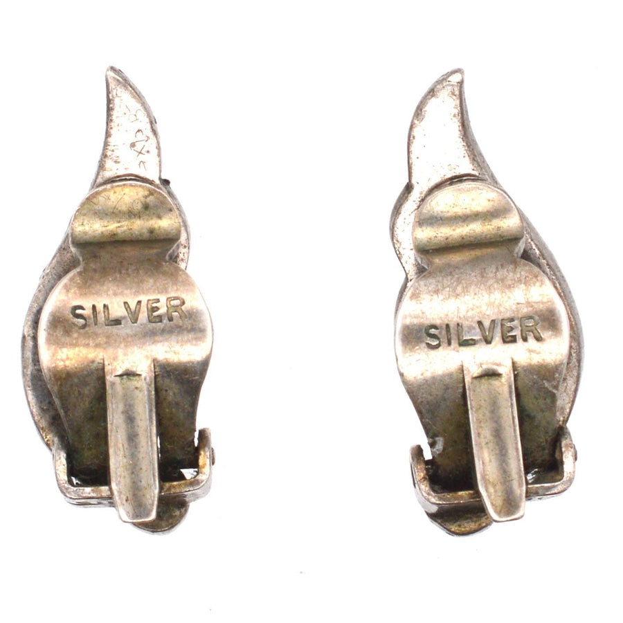 Close-up of vintage Art Deco silver clip-on earring clasps marked 'SILVER', showcasing intricate design details.