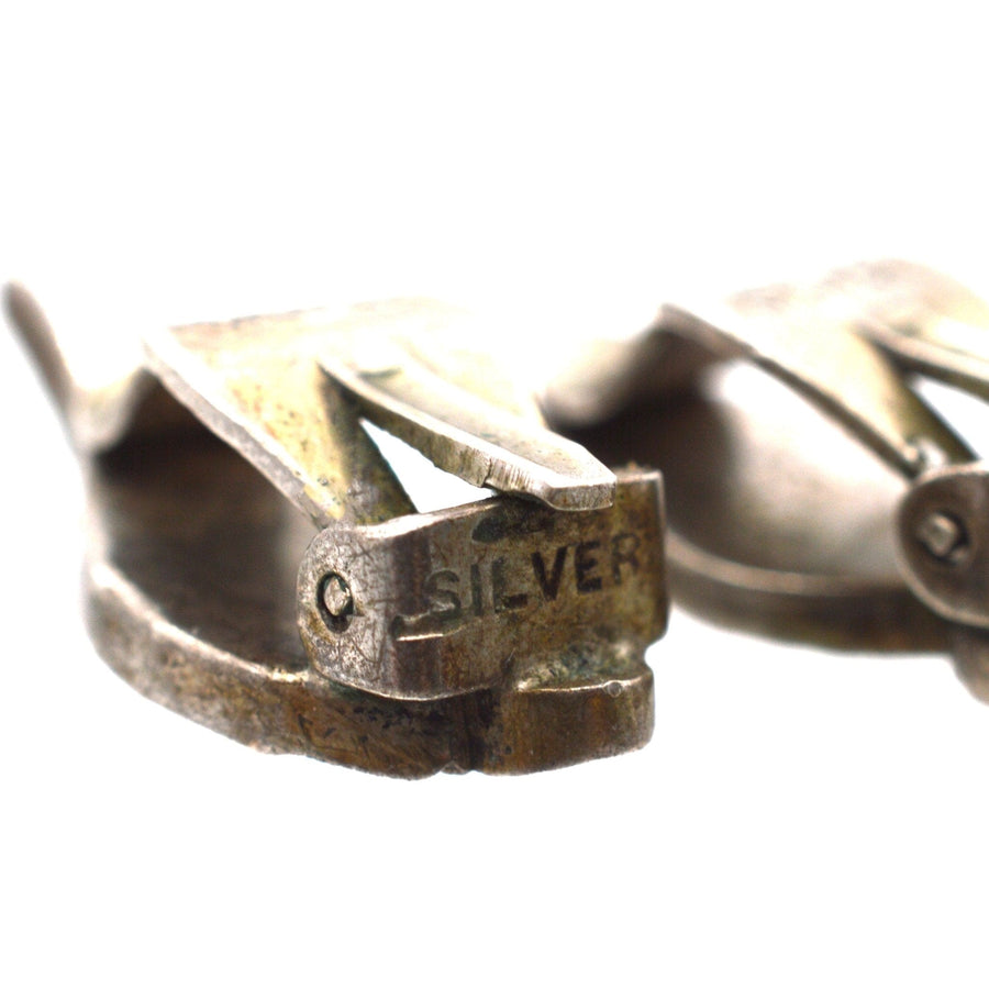 Close-up of vintage silver clip-on earring mechanism with 'SILVER' marking, showcasing Art Deco style.