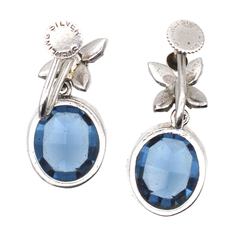 Art Deco silver earrings featuring inky blue sapphire color paste stones and intricate diamond paste tops.