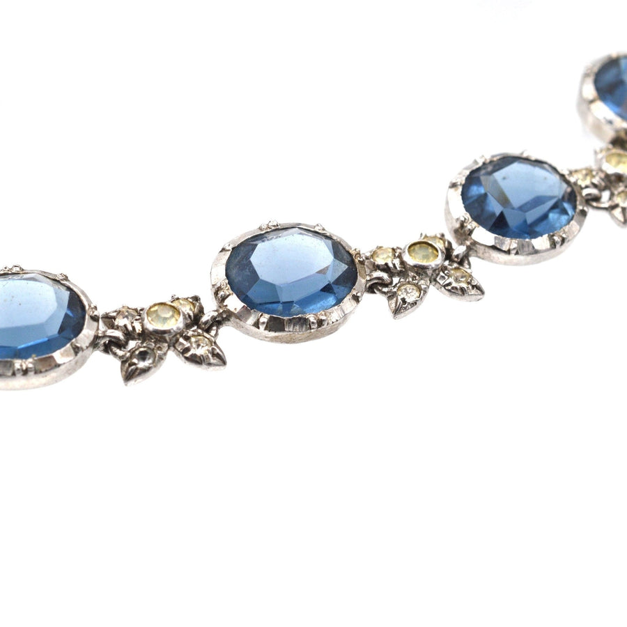 Art Deco silver necklace featuring blue sapphire and diamond paste stones in a floral setting.