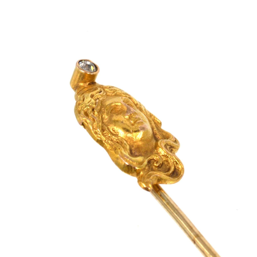 Art Nouveau 15ct gold pin featuring a woman's portrait adorned with a diamond, embodying the elegant curves of the period.