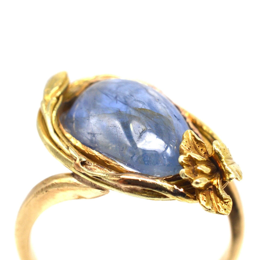 Art Nouveau 18ct gold ring featuring large cabochon Kyanite and flower design, showcasing blue and gold colors.
