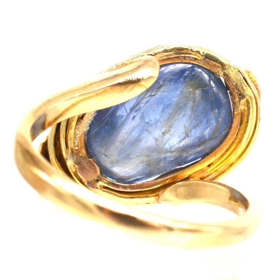 Art Nouveau 18ct gold ring featuring a large blue cabochon kyanite stone in a floral design.