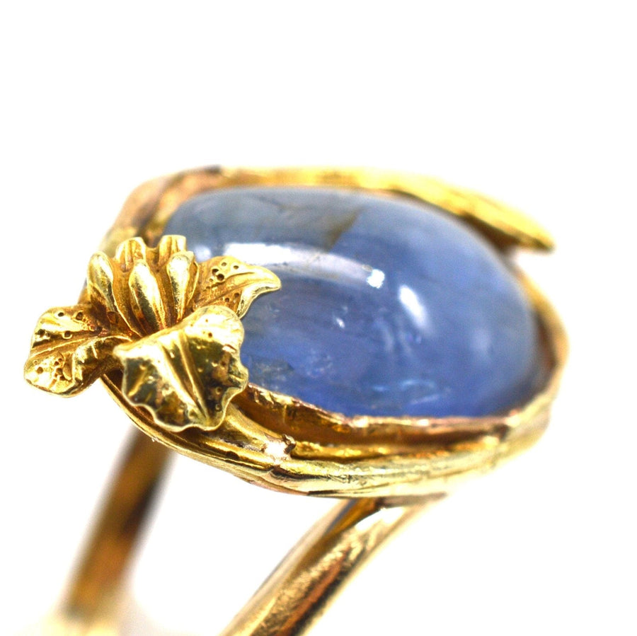 Art Nouveau 18ct gold ring featuring large blue Kyanite cabochon with flower and bud detail.
