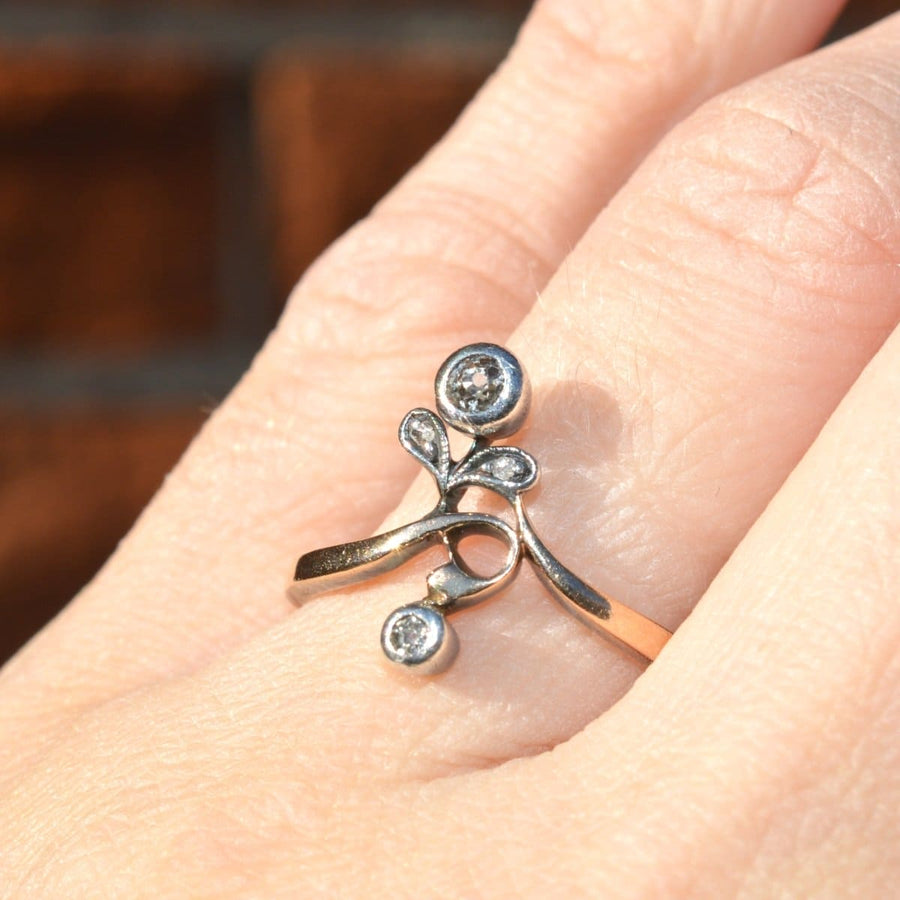 Austro-Hungarian Art Nouveau Silver and Gold flower ring with diamond accents worn on a hand.