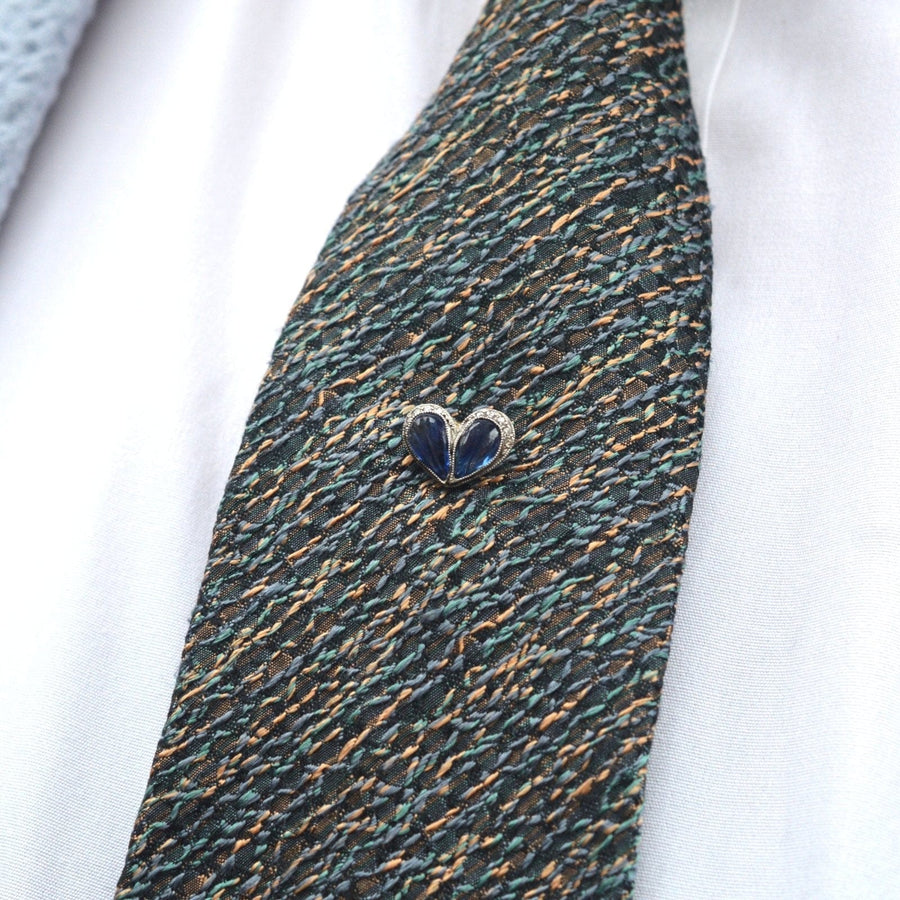 Belle Époque heart tie pin featuring carved sapphires and diamonds, displayed on a textured tie.