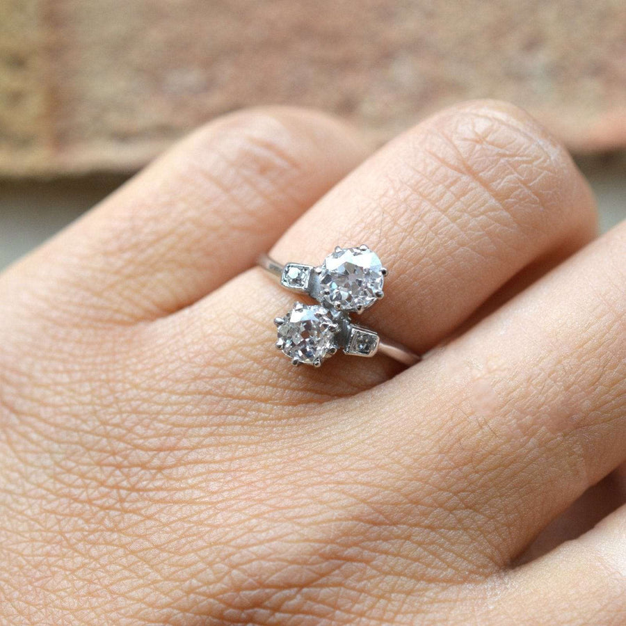 Belle Époque platinum and diamond 'Toi et Moi' crossover ring featuring two brilliant diamonds on a hand.