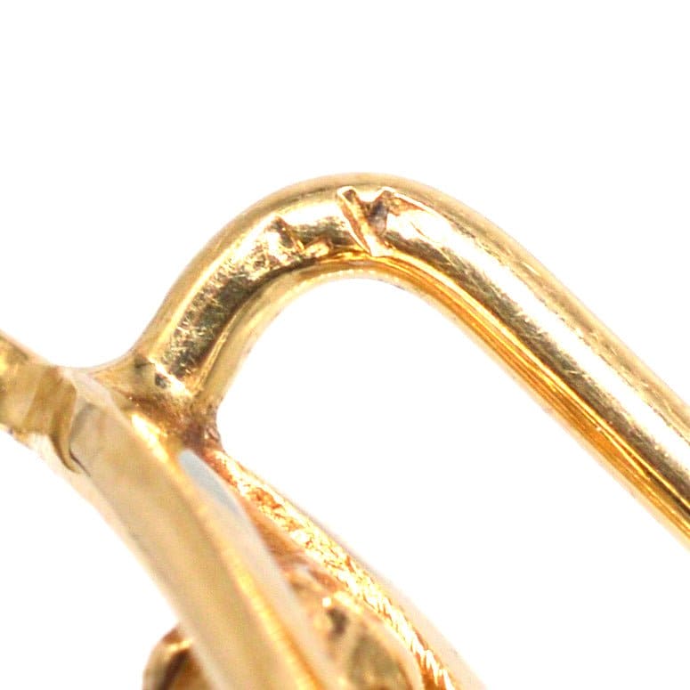 Close-up of Edwardian 15ct gold wishbone tie pin showcasing its intricate design and polished finish.