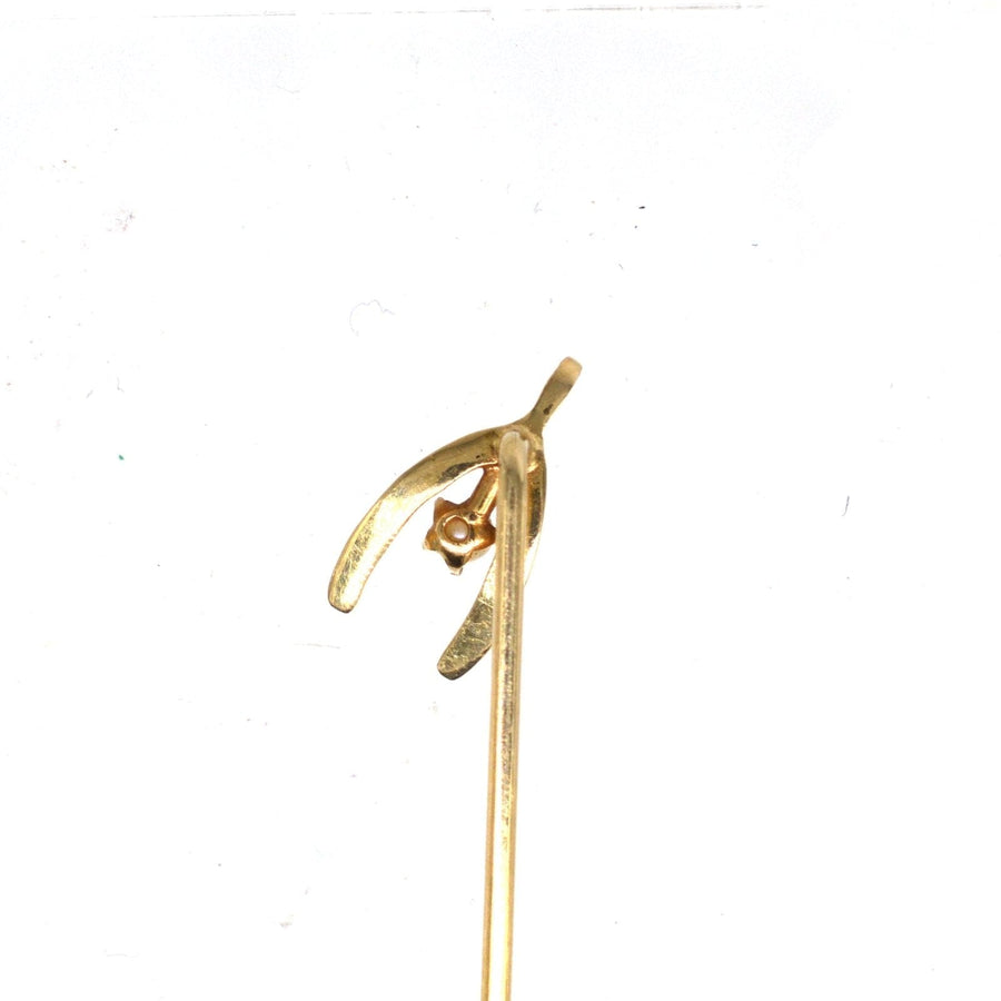 Edwardian 15ct gold wishbone tie pin with natural pearl, symbolizing luck and elegance on silk ties.