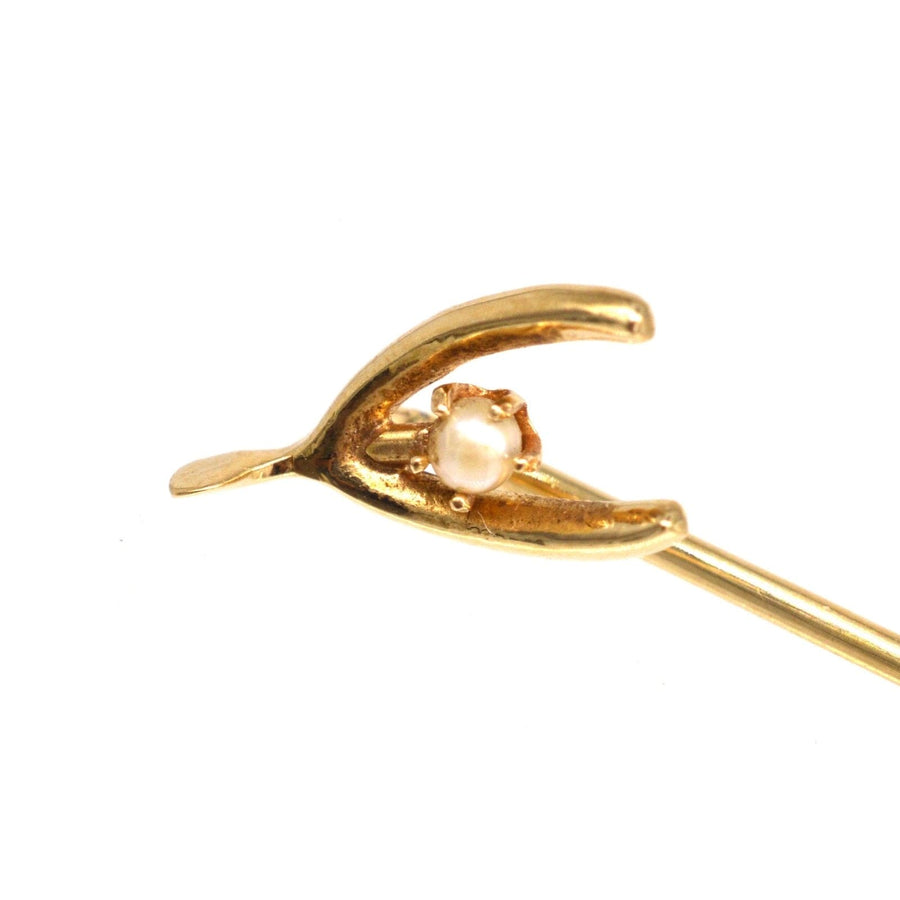 Edwardian 15ct gold wishbone tie pin featuring a natural pearl, symbolizing luck and hope for the future.