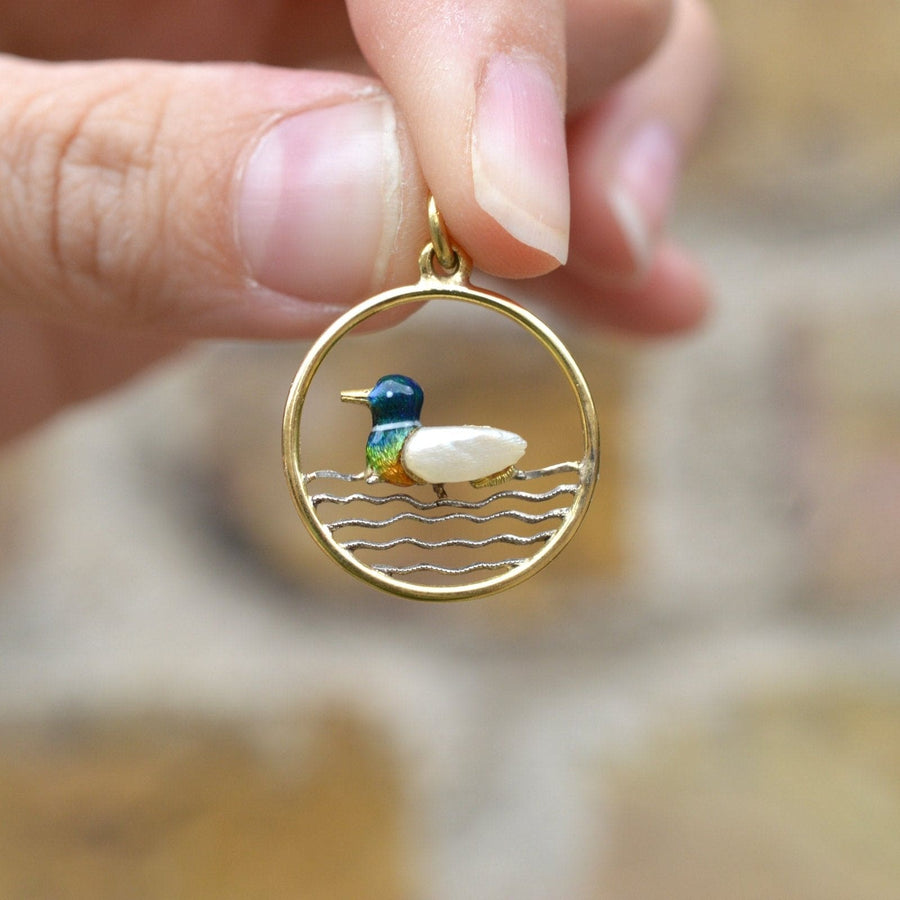 Edwardian 15ct gold duck pendant featuring baroque pearl and colorful enamel in a round frame.