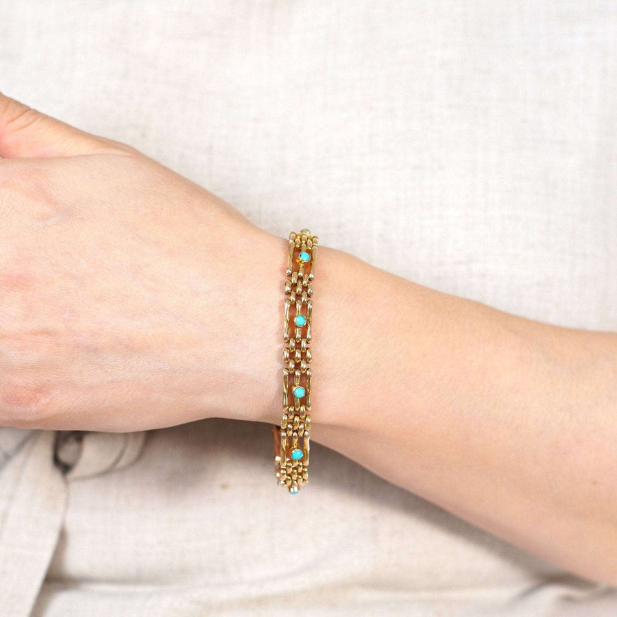 Edwardian 15ct gold gate bracelet with turquoise, elegantly worn on wrist, showcasing timeless design from circa 1910.
