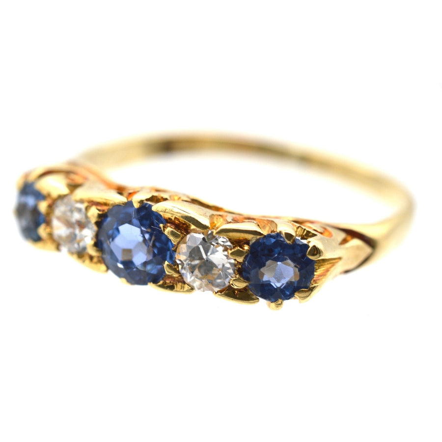 Elegant Edwardian 15ct gold ring featuring cornflower sapphires and diamonds in a half hoop design.