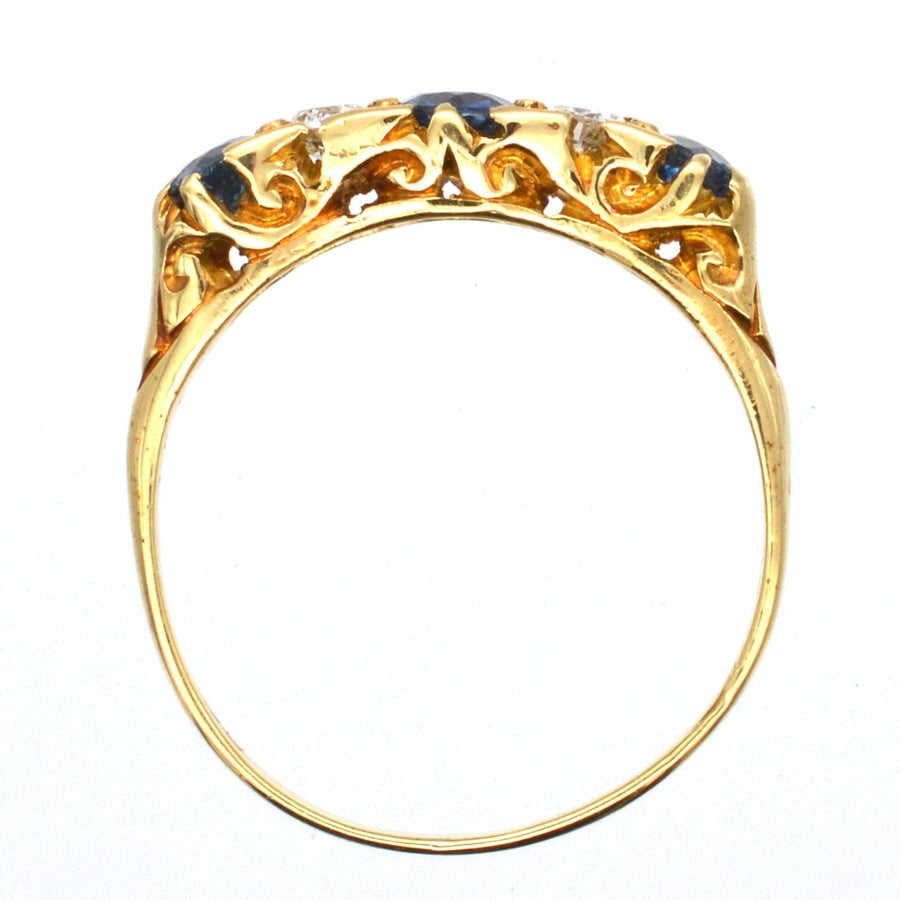 Elegant Edwardian 15ct gold ring featuring half-carved design, cornflower sapphires, and diamonds.