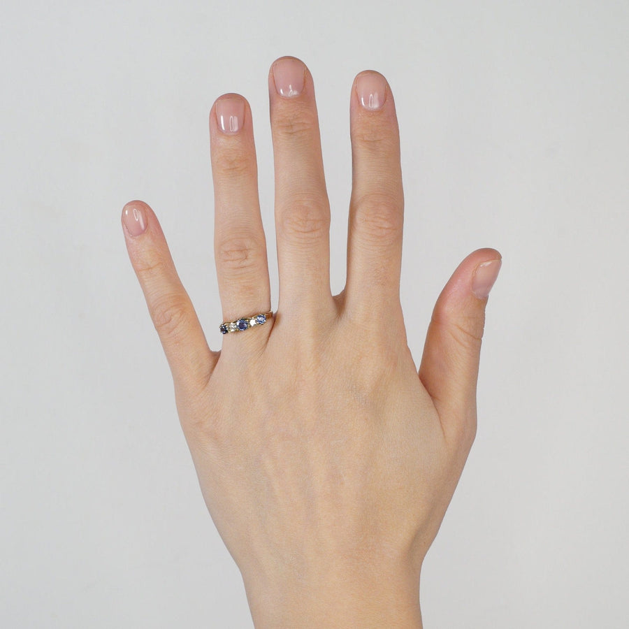 Elegant 15ct gold five stone ring featuring cornflower sapphire and diamond on a hand.