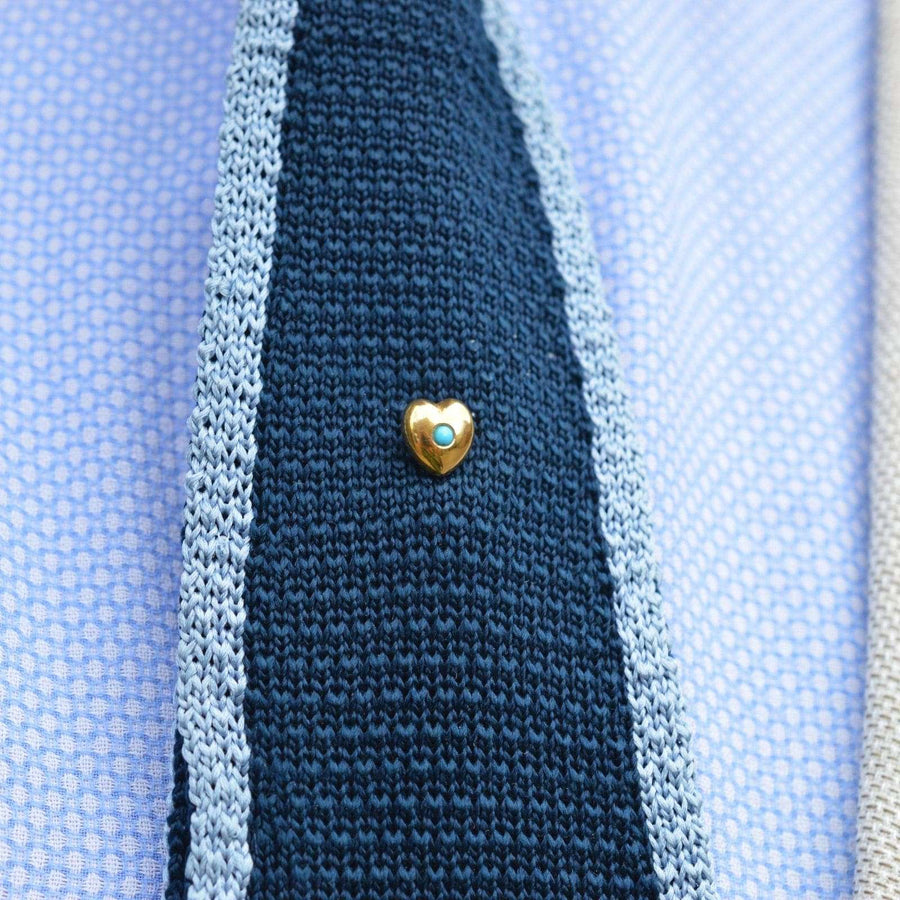 15ct gold heart tie pin with turquoise on a stylish knitted tie, showcasing elegance and sentimentality.