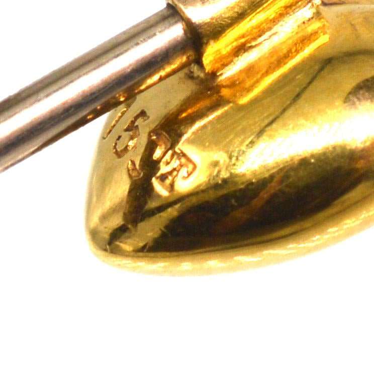 Close-up of a 15ct gold heart tie pin, showcasing the gold hallmark and craftsmanship details.
