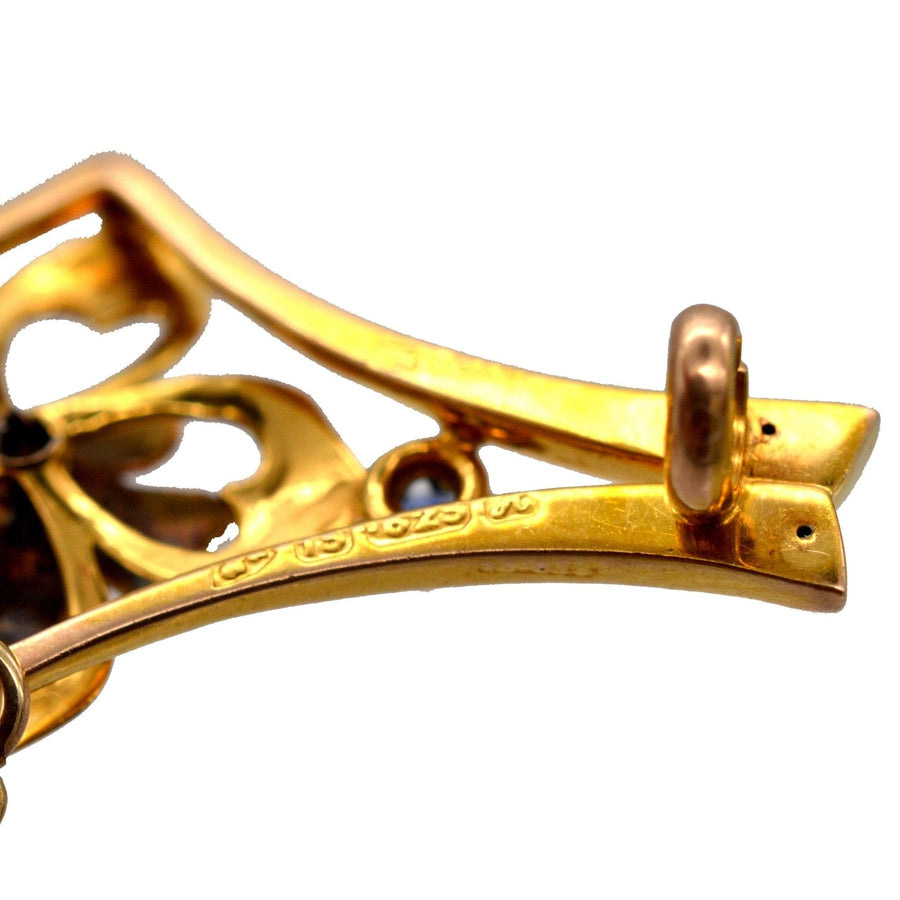 Close-up of the back of an Edwardian 15ct gold flower bar brooch showcasing intricate design and hallmark details.