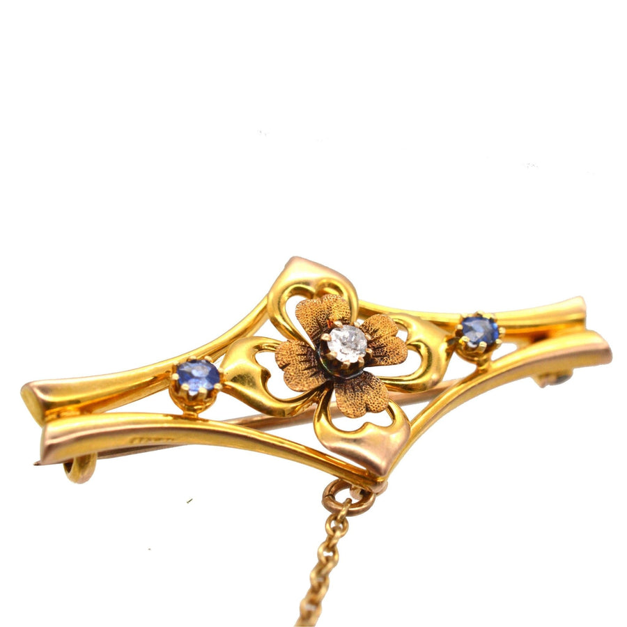 Edwardian 15ct gold flower bar brooch with diamond and sapphire accents, crafted in 1910.
