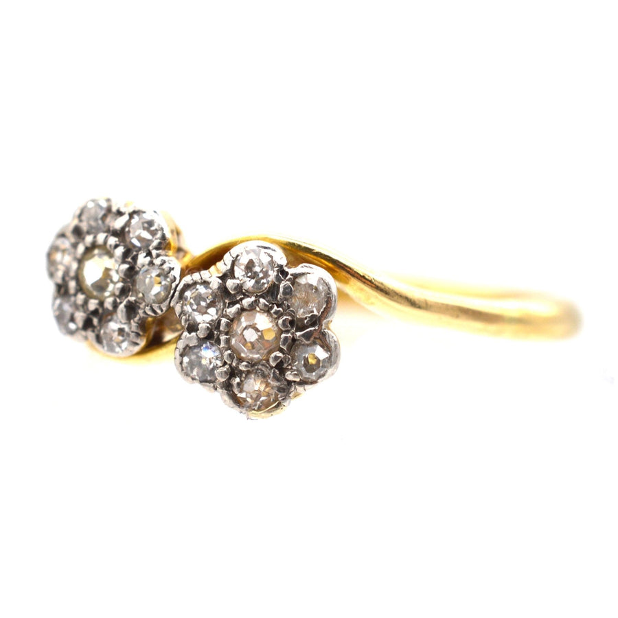 18ct gold double diamond cluster crossover ring featuring two delicate diamond flower designs.