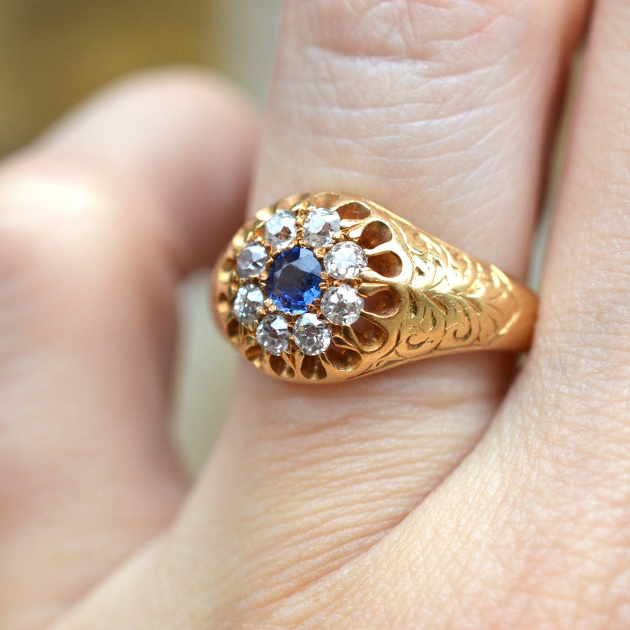 Edwardian 18ct gold cluster ring with sapphire and old mine cut diamonds, intricate foliate engraving.