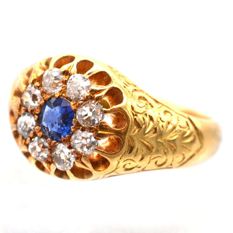 Edwardian 18ct gold cluster ring featuring a sapphire and old mine cut diamonds, intricately engraved design.