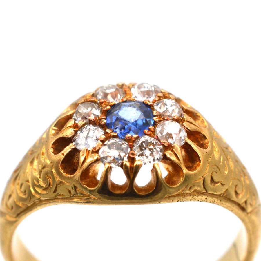 Edwardian 18ct gold cluster ring with sapphire and old mine cut diamonds, detailed foliate engraving.